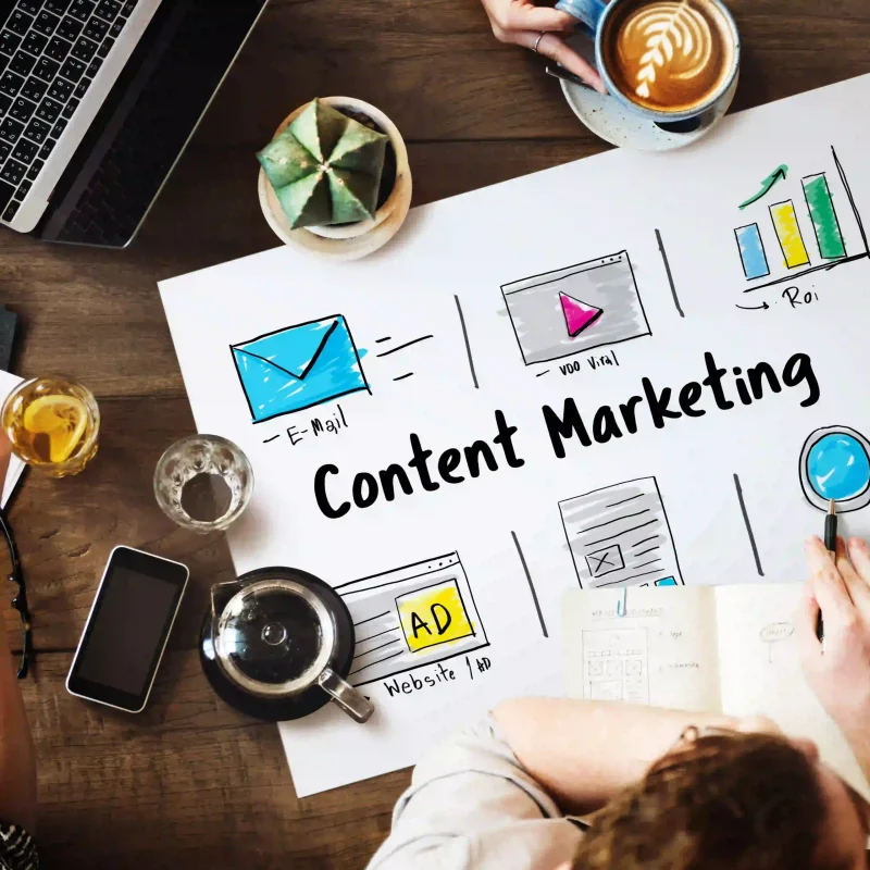 Content marketing strategy illustration showing email marketing, video content, website ads, and ROI planning on a desk setup